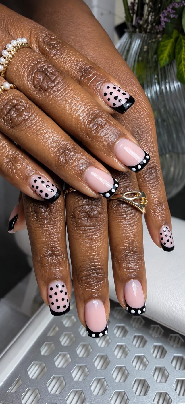 Long pale-pink nails with black French tips and white dotted nail art